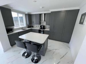 a kitchen with gray cabinets and a white counter top at The Earls in Newry