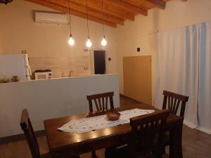 a dining room with a table and chairs and a kitchen at las lavandas alojamiento in Tinogasta