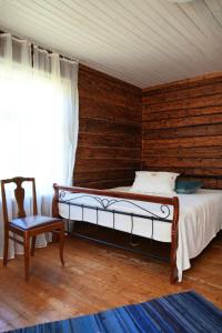a bedroom with a bed and a chair and a window at Farmhouseinn1923 