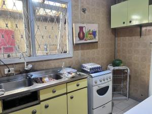 a kitchen with a sink and a stove at hostel brasil in Águas da Prata