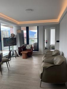 a living room with a couch and chairs and a tv at Brand New Modern 2 BR Condo in Heart of Downtown Vancouver in Vancouver