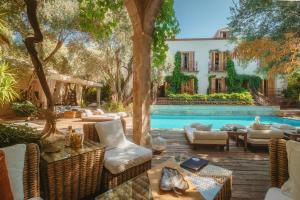 an outdoor patio with a pool and chairs and a building at Jade Residence in Oludeniz