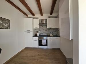 a kitchen with white cabinets and a stove at Apartment Lotta in Sali +4 photos