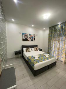 a bedroom with a bed and a large window at Ballarò’s Vibe in Palermo