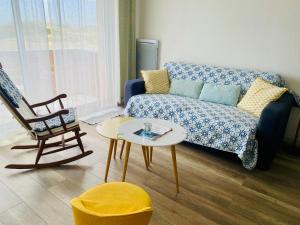 - un salon avec un canapé et une chaise dans l'établissement La Timonerie - La Caraque 35, vue mer et dunes classé 2 étoiles, à Fort-Mahon-Plage