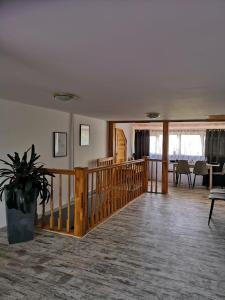 a living room with a wooden staircase with a potted plant at Agroturystyka Pod Podkową in Darłowo