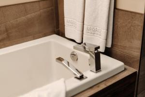 a white sink in a bathroom with towels at 2 bedroom suite with access to Sommet Saint-Sauveur in Saint-Sauveur-des-Monts