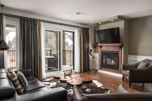 a living room with a couch and a fireplace at 2 bedroom suite with access to Sommet Saint-Sauveur in Saint-Sauveur-des-Monts
