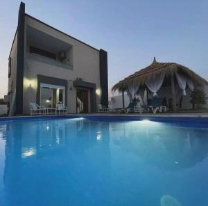 a large swimming pool in front of a house at Ali hot villa in Djerba