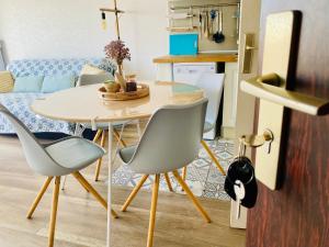 - une table à manger et des chaises dans le salon dans l'établissement La Timonerie - La Caraque 35, vue mer et dunes classé 2 étoiles, à Fort-Mahon-Plage