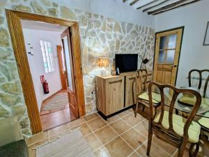 a living room with a television and a table and chairs at Morada El Rincón in Villanueva de los Infantes
