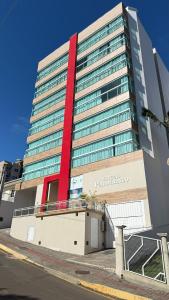 a large building with a red stripe on it at Apto Das Margaridas- 3 Quartos, Apto todo climatizado, amplo, confortável, ao lado do Parque Termal!! in Piratuba