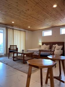 une chambre avec un lit et des tables dans une pièce dans l'établissement Trim Cottage By Lehriyat Retreats, à Mussoorie