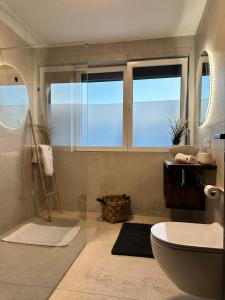 un bagno con un water, un lavandino e una finestra di Romantic coastal apartment with sea views a Komarna