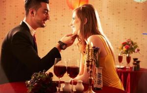 a man and a woman sitting at a table with wine glasses at Chez Lilly in Oranjestad