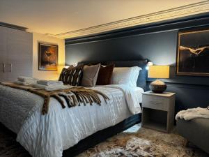 une chambre avec un grand lit et un mur bleu dans l'établissement Manhattan-Style Chic Loft, Sleeps 5, Heart of Leeds, à Central Station