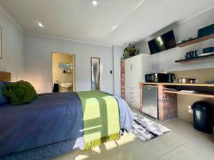 a large bedroom with a bed and a kitchen at The Courtyard in Vosburg