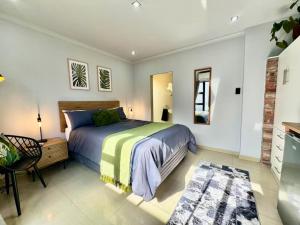 a bedroom with a bed and a table and a chair at The Courtyard in Vosburg
