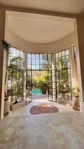 a large room with large windows and a pool at Casa Mag-Ha in Francisco Uh May