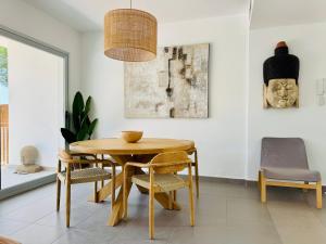 a dining room with a wooden table and chairs at Althaia Hills - Precioso adosado con terraza panorámica al mar y montaña in Altea