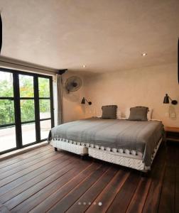 a bedroom with a bed and a large window at Casa Mag-Ha in Francisco Uh May
