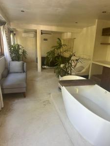 a bathroom with a tub and a chair and plants at Casa Mag-Ha in Francisco Uh May +24 photos