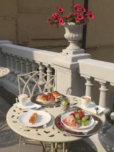 a table with two plates of food on a balcony at La Terrazza Vercelli Bed & Charme in Vercelli