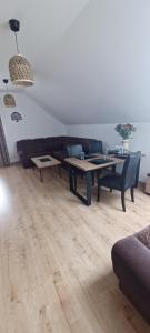 a living room with a couch and a table at Dębówka - apartament rodzinny in Wilcze