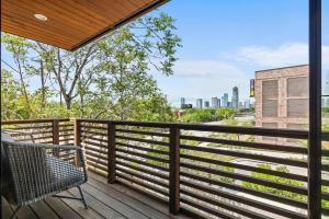 a balcony with a chair and a view of the city at Rooftop Deck, DT City Views, Modern Eastside Oasis in Austin