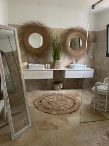 a bathroom with two sinks and two mirrors at Casa Di Lortu villa in Ajaccio +11 photos
