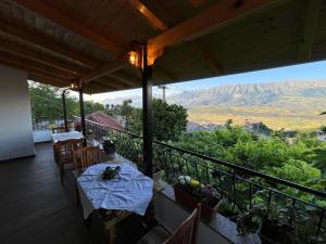 a table on a balcony with a view of mountains at Guest house Loloçi in Gjirokastër