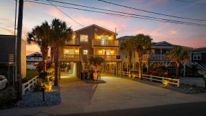 a large house with palm trees in front of it at Channel Surfer in Myrtle Beach