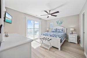 a white bedroom with a bed and a balcony at Channel Surfer in Myrtle Beach