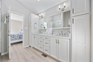a white bathroom with two sinks and a mirror at Channel Surfer in Myrtle Beach +93 photos