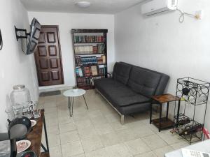 a living room with a couch and a book shelf at El depa de los cactus in Progreso