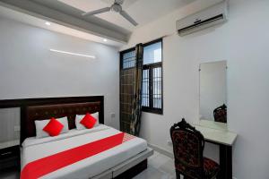 a bedroom with a bed and a desk and a window at Hotel O Elite Signature in Indirapuram