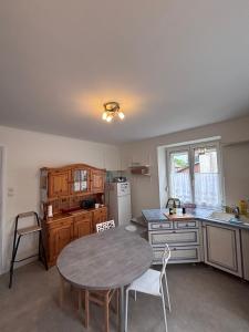a kitchen with a table and a table and chairs at Gite Nathalie in Lièpvre +16 photos