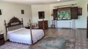 a bedroom with a bed and a window at Precioso chalet con gran algarrobo y piscina privada in La Jara
