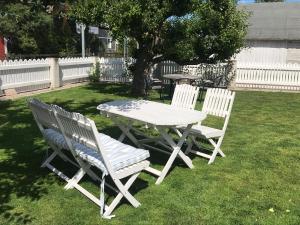 a white picnic table and two chairs in a yard at Kungsgatan 36 in Borgholm