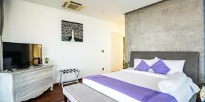 Un dormitorio con una cama grande con almohadas moradas. en Villa Nha Trang View Biển - View City, en Nha Trang 1 foto más