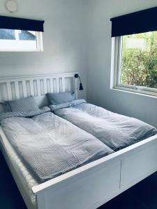 a white bed in a room with a window at Kungsgatan 36 in Borgholm