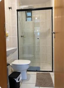 a bathroom with a toilet and a glass shower at Apartamento Próximo ao Mar in Bombinhas