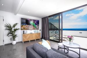 アレシーフェにあるVista Azul Penthouseのソファと大きな窓のあるリビングルーム