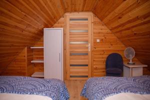 a room with two beds and a door in a cabin at Domki u Rybaka in Kąty Rybackie