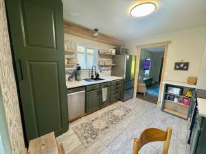 a kitchen with green cabinets and a sink and a table at Harbor Hideaway in Port Orchard
