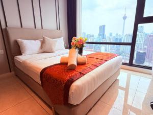 a bedroom with a bed with a vase of flowers at Luxury Axon Suites KLCC-PAVILION in Kuala Lumpur +83 photos