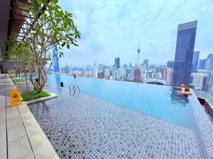 a swimming pool on top of a building with a city at Luxury Axon Suites KLCC-PAVILION in Kuala Lumpur