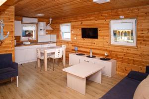a kitchen and living room in a log cabin at Domki u Rybaka in Kąty Rybackie