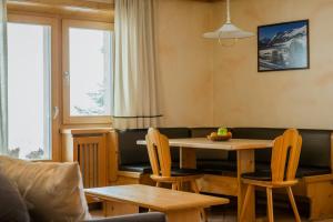 a living room with a couch and a table and chairs at Piccolo Larice - Livigno in Livigno