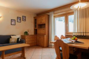 a living room with a table and a kitchen at Piccolo Larice - Livigno in Livigno